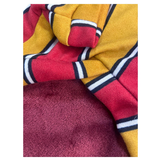 detalle del anterior afelpado color vino del sueter para perro con rayas mostaza y vino.
Material suave y terminco de zona de perros
