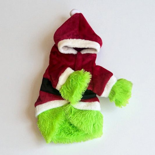 raje Grinch para perro con capucha roja y peluche verde, fondo interior con luces de Navidad.
