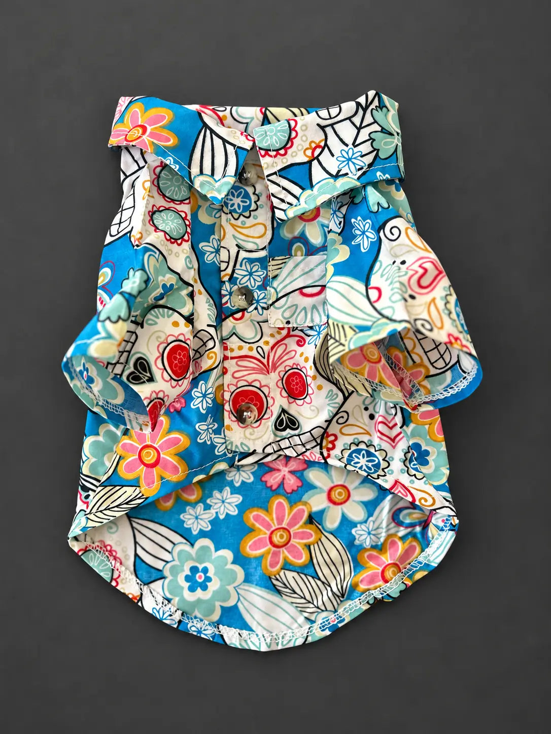Camisa para perro de manga corta con estampado de flores, corazones, mariposas y motivos coloridos en tonos turquesa, blanco y negro