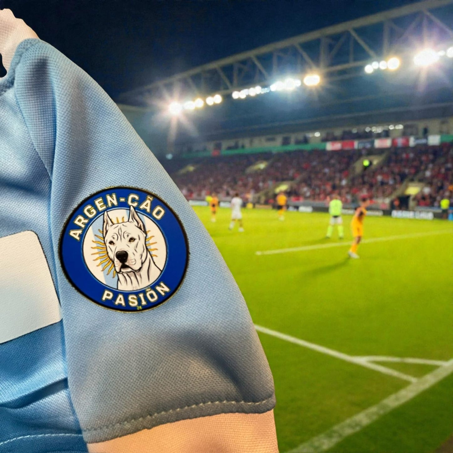 Detalle de calidad del parche especial en la manga de la playera de Argentina para perro en un estadio.