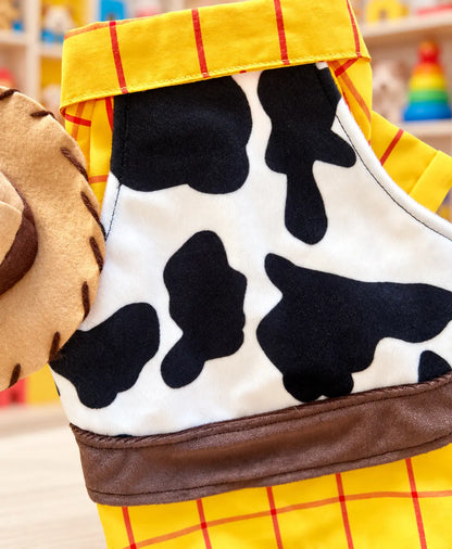 Detalle del disfraz de Woody para perro con estampado de vaca, camisa amarilla a cuadros y acabados inspirados en la vestimenta de un vaquero.