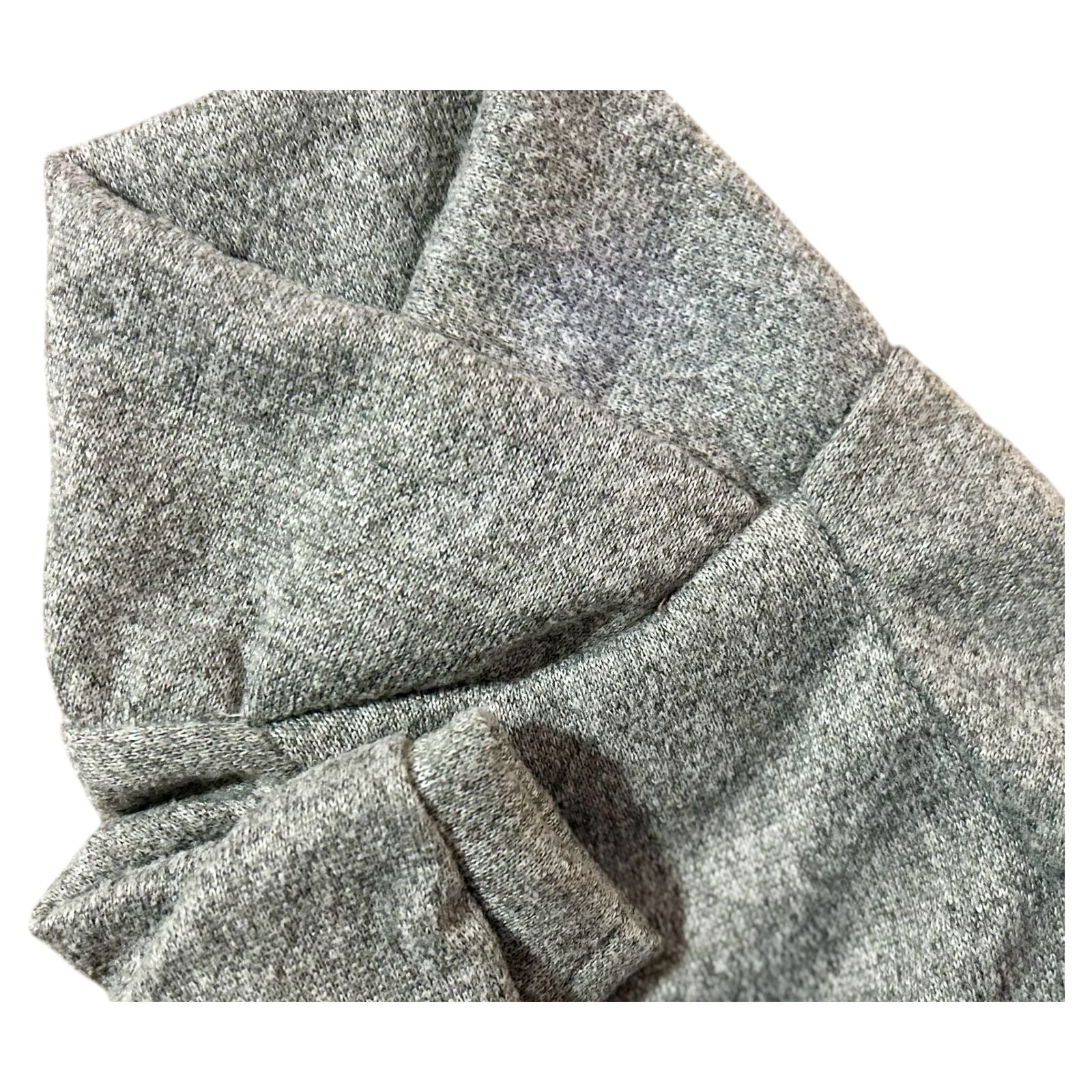 Detalle del sueter oslo gris, textura suave y diseño cruzado de la colección Invierno 2025.