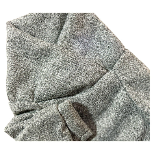 Detalle del sueter oslo gris, textura suave y diseño cruzado de la colección Invierno 2025.